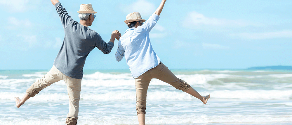 An older couple frolicking on the beach